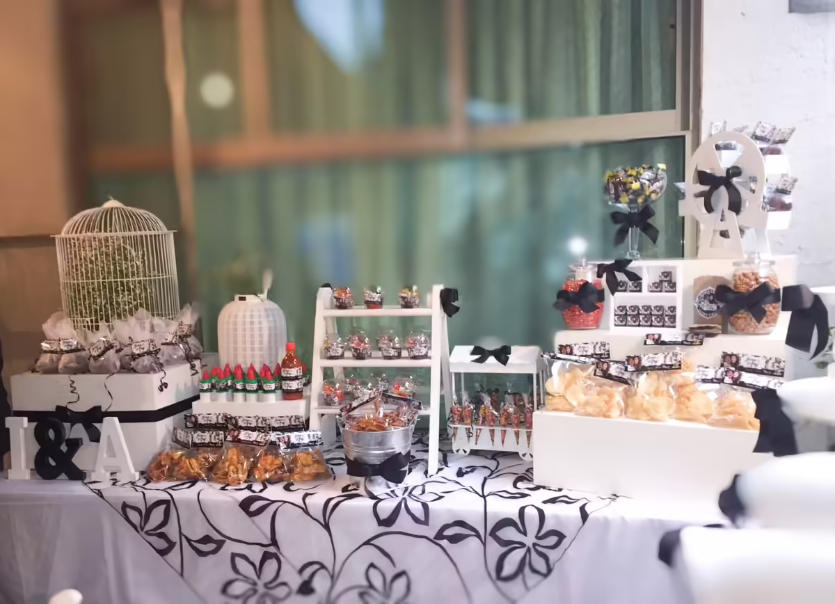 Mesa de dulces elegante blanco y negro para evento corporativo en CDMX con jaula, mini cupcakes y arreglos sofisticados