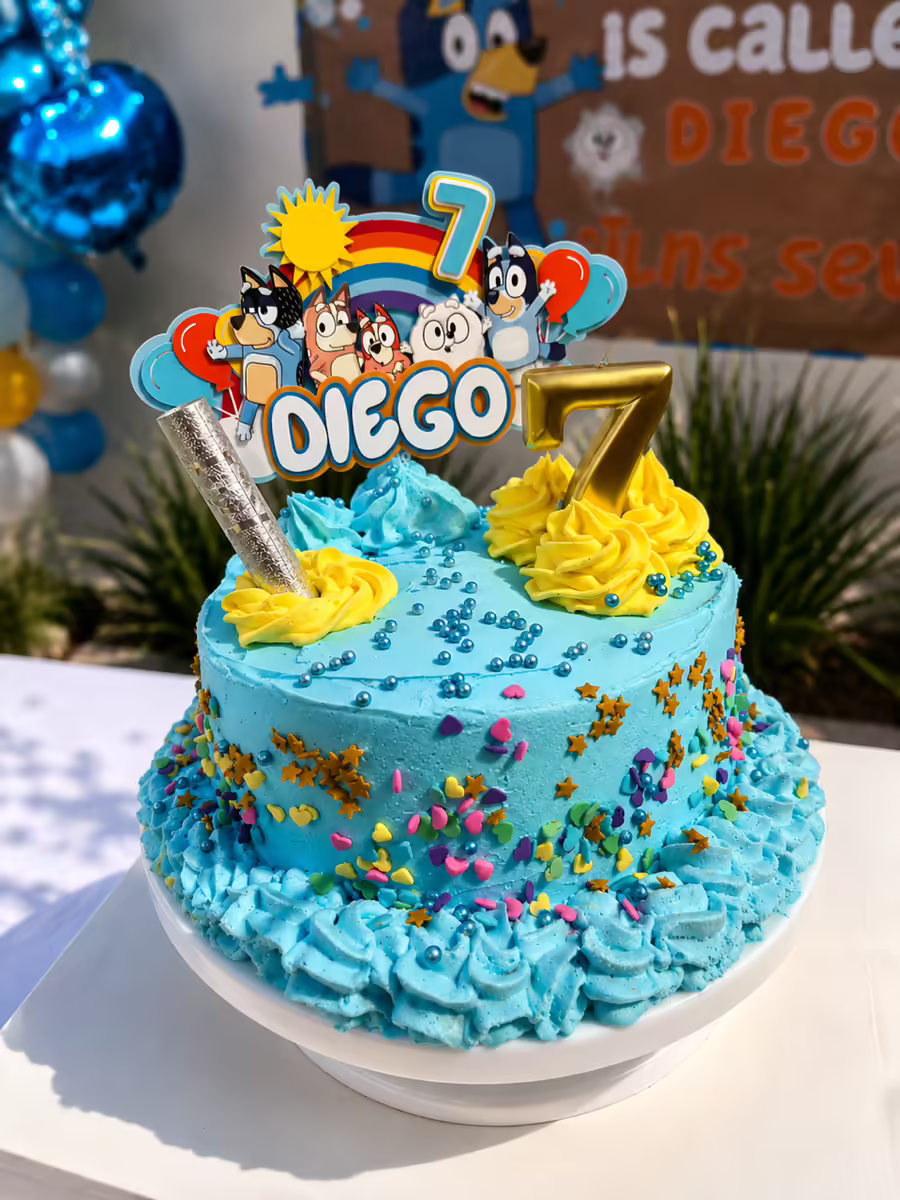 Pastel de fondant Bluey terminado con personalizacion completa Diego 7 anos, decoracion tematica, sprinkles dorados y vela numero 7 para cumpleanos infantil en CDMX