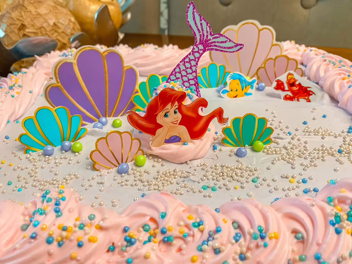 Pastel de la Sirenita Ariel con conchas decoradas, sirena Ariel de fondant, perlas comestibles y olas de buttercream en paleta turquesa-coral-dorado para cumpleanos de nina tematico en CDMX